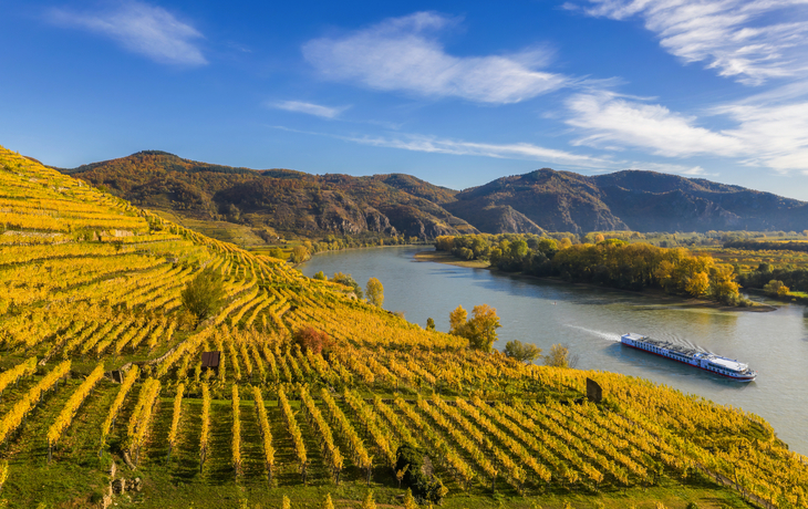 Herbstpanorama des Wachautals (Unesco-Weltkulturerbe) mit Schiff auf der Donau in der Nähe des Dorfes Weißenkirchen in Niederösterreich
